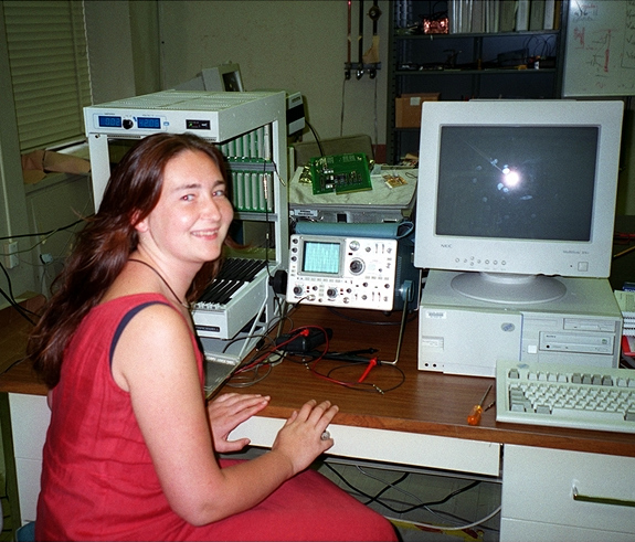 Woman smiling in front of computers.